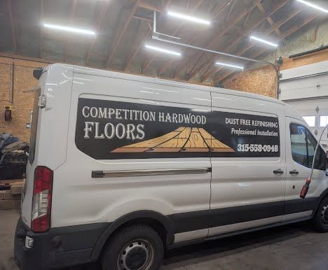 Competition Hardwood Floors white work van with the company logo, Dust Free Refinishing, Professional Installation and 315-558-0948 on the side